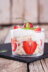 A glass dessert cup filled with layers of meringue, yogurt, and strawberries, topped with whipped cream and a strawberry.